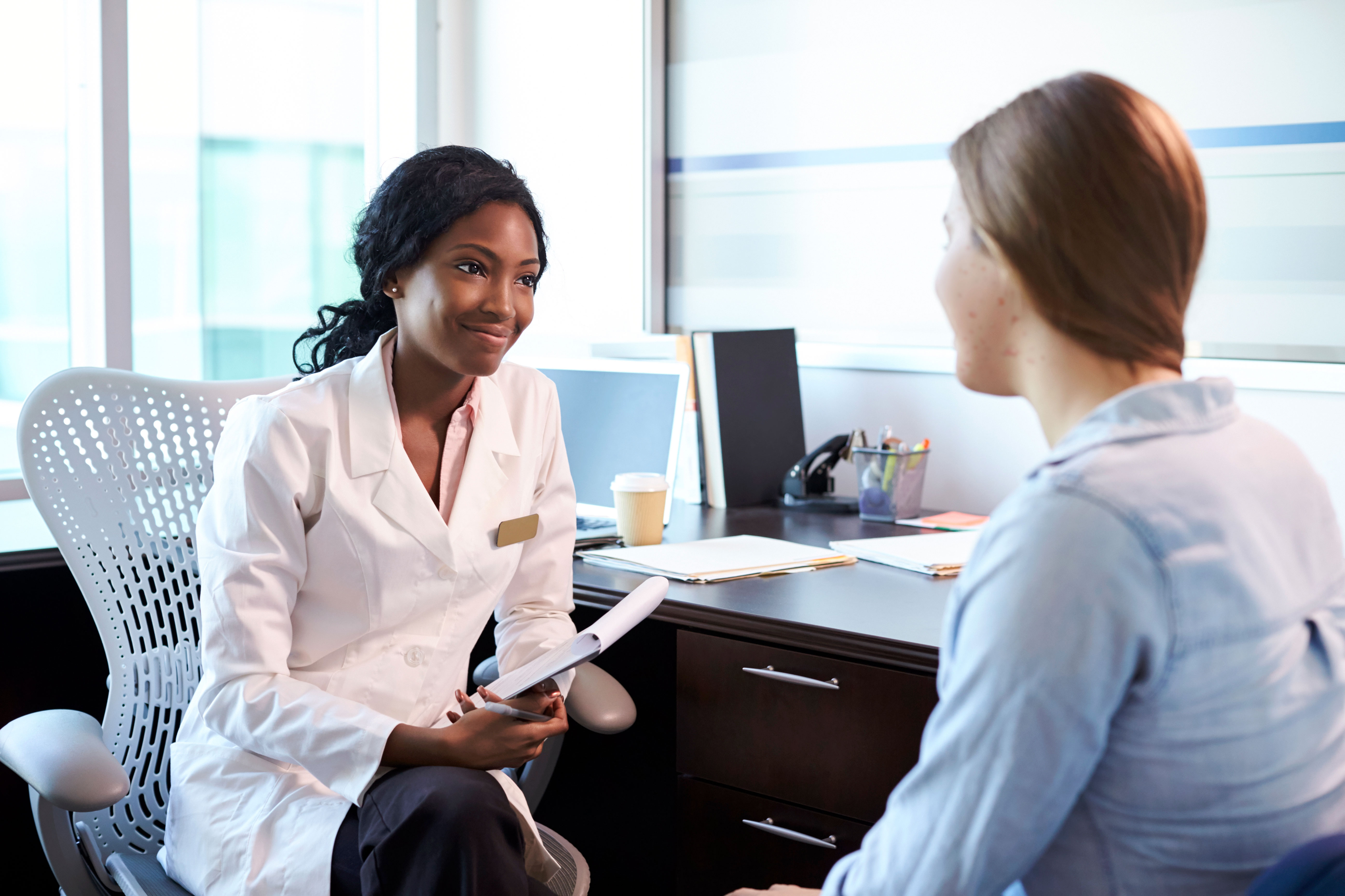 Healthcare professional discussing treatment with a female patient