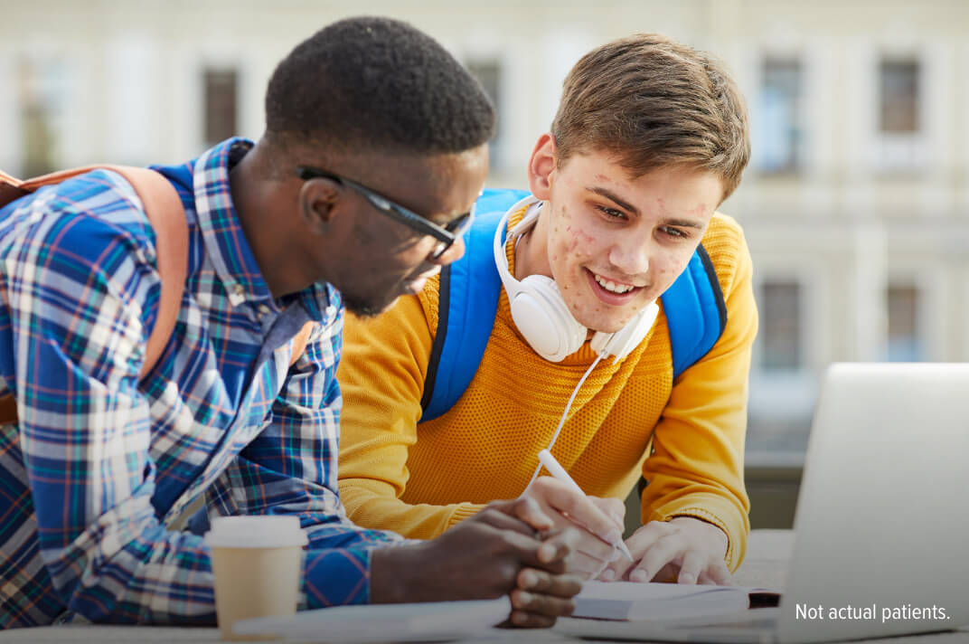 Two male students wearing backpacks working together on a class project