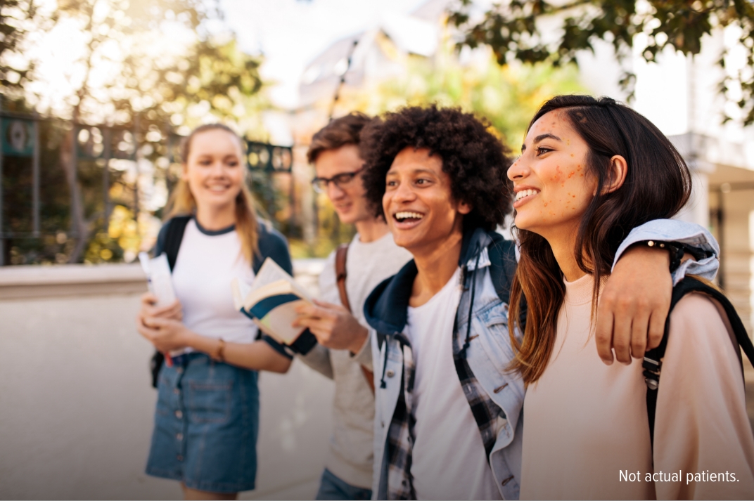 Group of teens smiling standing outside an urban area