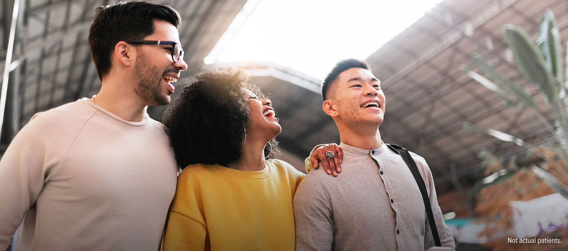 Young woman laying on her bed and touching her face while looking at herself in a small handheld mirror